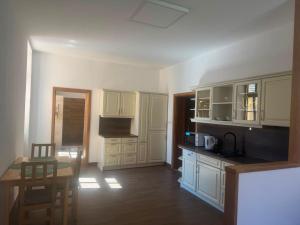 a kitchen with white cabinets and a table and a dining room at Apartmán Netolice in Netolice +11 photos