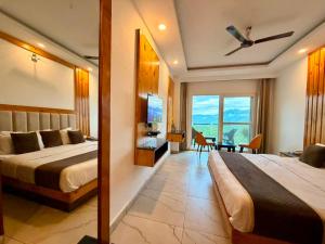 a hotel room with two beds and a dining room at Pine View Luxury Resort With Mountain View & Premium Rooms Mussoorie in Mussoorie +61 photos