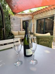 a bottle of wine and two wine glasses on a table at Cabanon in Sanary-sur-Mer