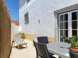 a patio with a table and chairs and a building at Casa do Chafariz in Torres Vedras