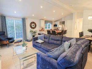 a living room with a blue couch and a kitchen at Luxury 2 Bedroom Lodge at White Cross Bay, Windermere in Windermere