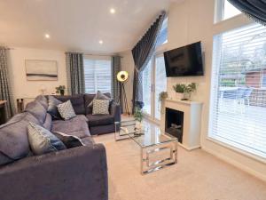 a living room with a couch and a tv at Luxury 2 Bedroom Lodge at White Cross Bay, Windermere in Windermere