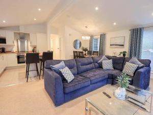 a living room with a blue couch and a kitchen at Luxury 2 Bedroom Lodge at White Cross Bay, Windermere in Windermere