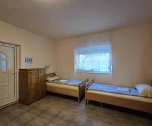a room with two beds and a window at PENSIUNEA BIO in Coltău