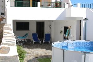 a house with a swimming pool and blue chairs at Port'Espada Countryhouse in Marvão