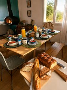 a table with bread and drinks and orange juice at Chez Billie et Moon in Landéda