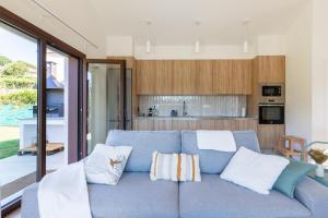 a living room with a blue couch with pillows at A casa das Ías in Tourón