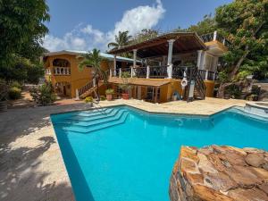 a swimming pool in front of a house at Caribbean Shores Belize in Hopkins