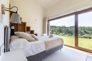 a bedroom with a bed and a large window at A casa das Ías in Tourón