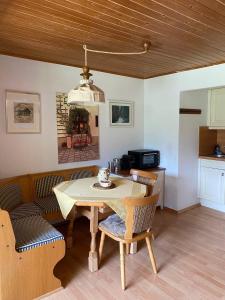 a dining room with a table and chairs and a kitchen at Haus Wäscher in Hirschegg