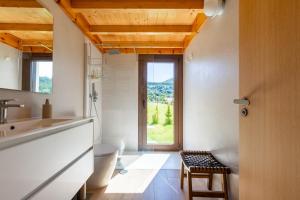 a kitchen with a window and a stool in a room at A casa das Ías in Tourón +22 photos