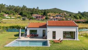 a small house with a pool in the yard at A casa das Ías in Tourón
