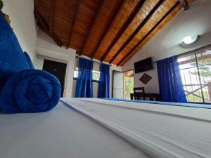 a room with a bed with blue sheets on it at Hotel Cristo Rey Campestre in Los Santos
