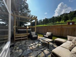 a patio with a couch and chairs and a table at The Pink House in Banner Elk