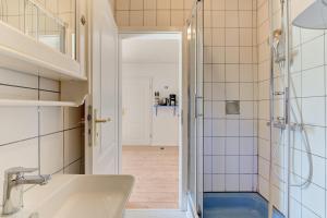 a bathroom with a shower and a sink at Reetdachhaus Sünsbarg in Simonsberg