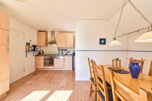 a kitchen and dining room with a wooden table and chairs at Reetdachhaus Sünsbarg in Simonsberg