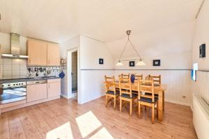 a kitchen and dining room with a table and chairs at Reetdachhaus Sünsbarg in Simonsberg