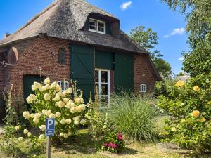 an old brick house with a thatched roof at Reetdachhaus Sünsbarg in Simonsberg +13 photos