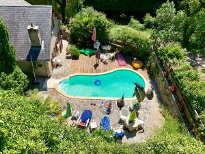 an overhead view of a swimming pool with chairs and umbrellas at La Caze in Saint-Pierre-des-Tripiers