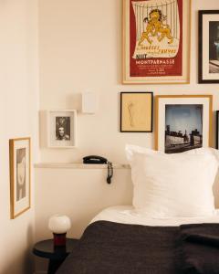 a bedroom with a bed and pictures on the wall at Le Pigalle, a Member of Design Hotels in Paris