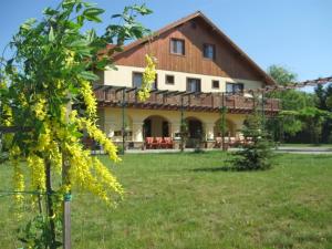 una grande casa con un cortile con un albero di Dedesi Vendégház Zalalövő a Zalalövő