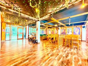 a room with a wooden floor and tables and chairs at Pine View Luxury Resort With Mountain View & Premium Rooms Mussoorie in Mussoorie