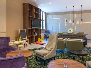 a living room with a couch and chairs and tables at Mercure Jelenia Góra in Jelenia Góra