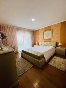 a bedroom with a large bed and a window at Casa Dourado Ramos in Vila do Conde