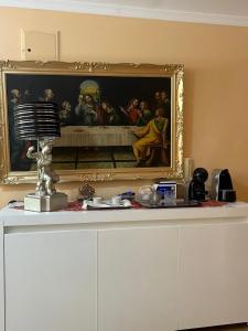 a painting on a wall above a white cabinet at Casa Dourado Ramos in Vila do Conde
