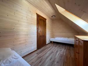 a wooden room with a bed and a staircase at Domki Vesper Międzywodzie in Międzywodzie