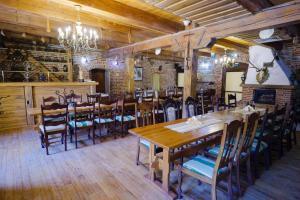 a dining room with a wooden table and chairs at Hanul Moara cu Noroc in Ineu +27 photos