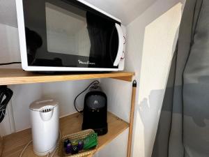 a microwave sitting on top of a shelf at Studio Cosy & Chic in Angoulême +6 photos
