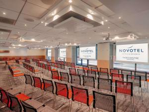 a large room with chairs and a stage with screens at Novotel Paris Centre Tour Eiffel in Paris