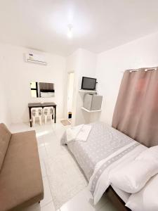 a white bedroom with a bed and a desk at Olliz Huvila in Siquijor