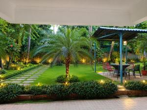 a palm tree in a garden with a table and chairs at Beach Resort in 1 in North goa