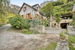 a house with a white fence and a driveway at La Caze in Saint-Pierre-des-Tripiers