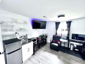 a kitchen and living room with a sink and a tv at Saint Augustine 3BR PetFriendly Fenced Backyard in St. Augustine