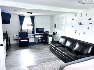a living room with a black leather couch and a table at Saint Augustine 3BR PetFriendly Fenced Backyard in St. Augustine +33 photos