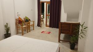 a bedroom with a bed and a desk and chairs at villa calm haven in Unawatuna