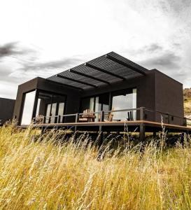 a black house sitting on top of a field at Finca Ocho Cerros in Tornquist