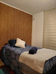 a bedroom with a bed with two pillows on it at Villarrica Céntrico in Villarrica