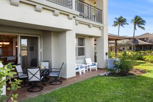 a patio with chairs and a table in front of a house at Mauna Lani Fairways 903 in Waikoloa