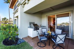 a patio with a table and chairs and a kitchen at Mauna Lani Fairways 903 in Waikoloa +54 photos