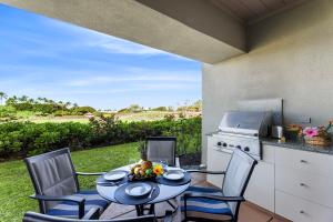 a patio with a table and chairs and a kitchen at Mauna Lani Fairways 903 in Waikoloa