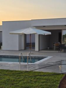 a white umbrella sitting next to a swimming pool at Elia Serenity House in Anarita