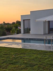 a swimming pool in front of a house at Elia Serenity House in Anarita