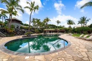 a pool at a resort with palm trees at Mauna Lani Fairways 1101 in Waikoloa