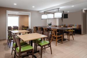 a dining room with wooden tables and chairs at Garner Hotel Macon West by IHG in Macon