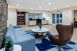 a living room with a couch and a table at Garner Hotel Macon West by IHG in Macon