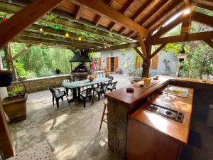 an outdoor kitchen and dining area with a table at La Caze in Saint-Pierre-des-Tripiers